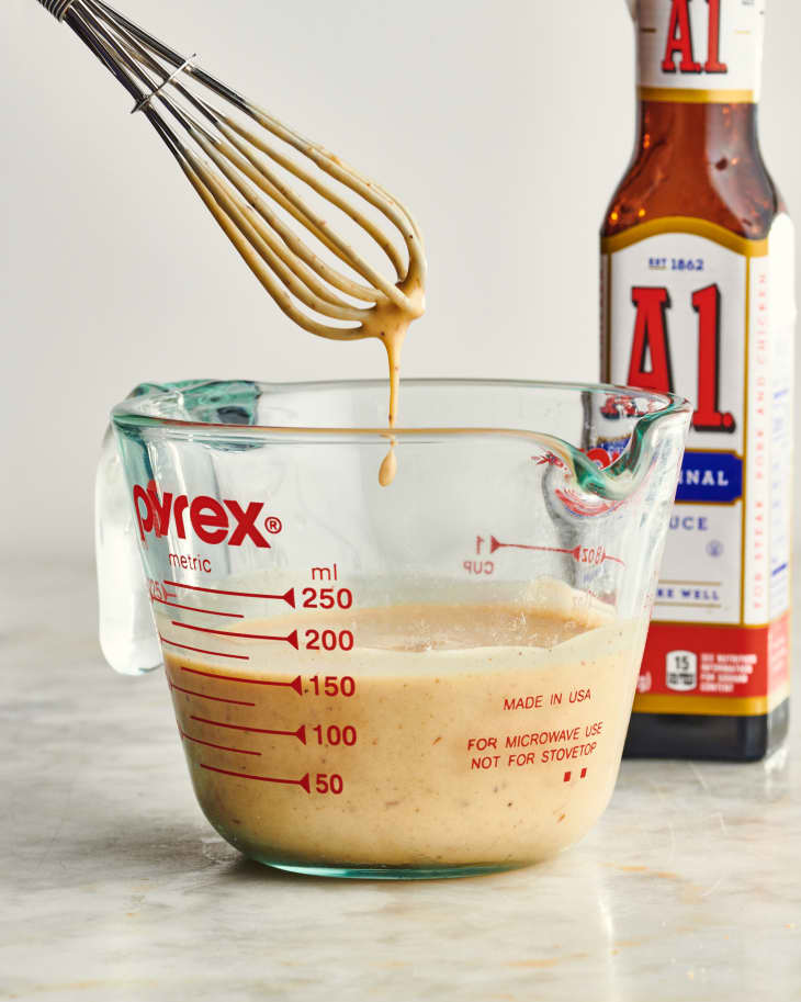 whisk dripping into a pyrex measuring glass