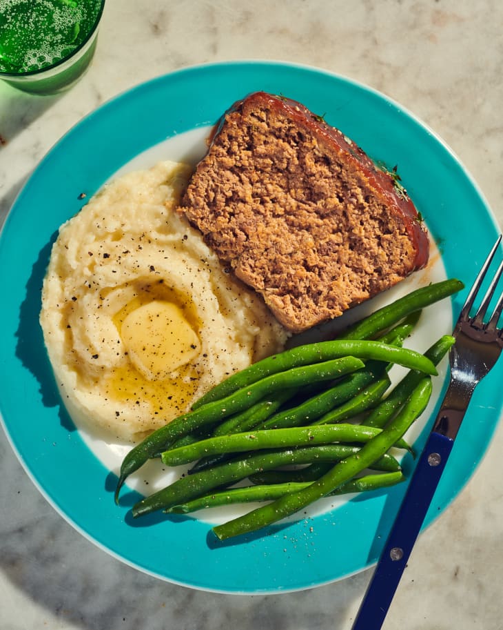 otameal meatloaf on a plate with potatoes grits and beans