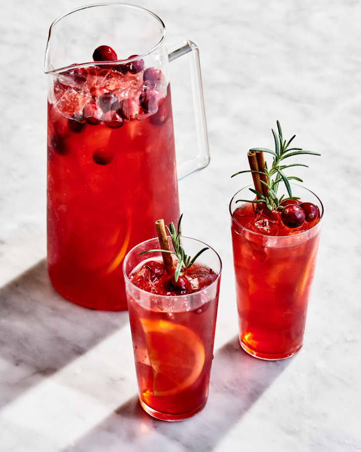 A pitcher of Pimms Winter Punch next to two glasses of punch