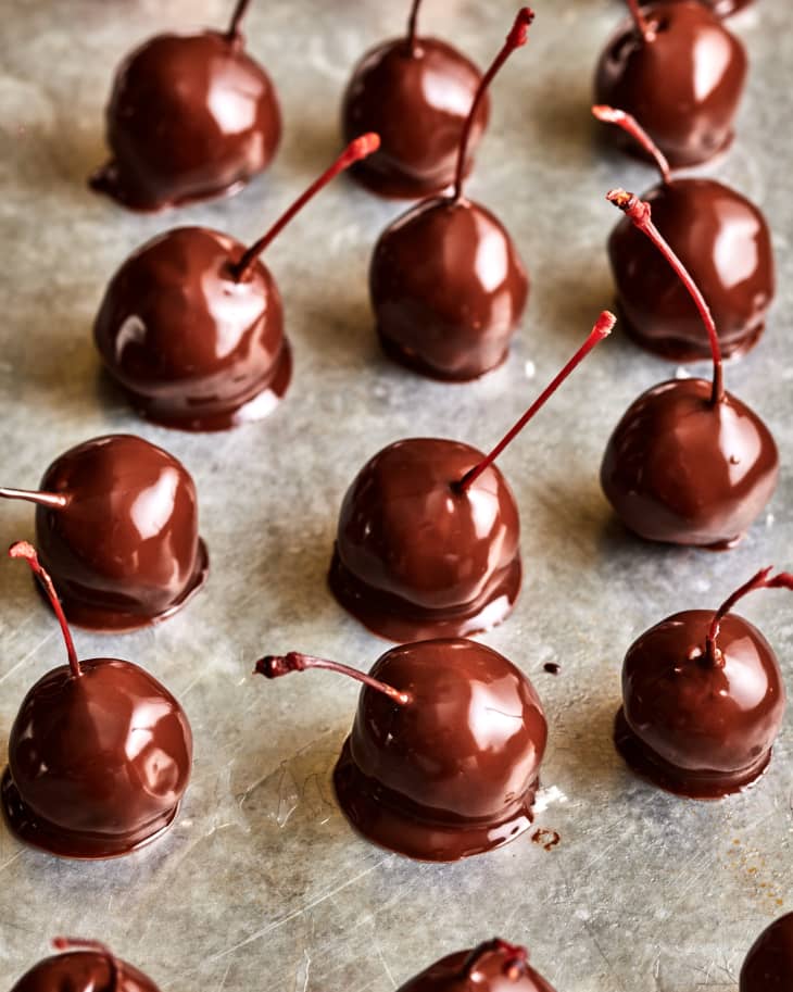 chocolate covered cherries lined up on a sheet pan