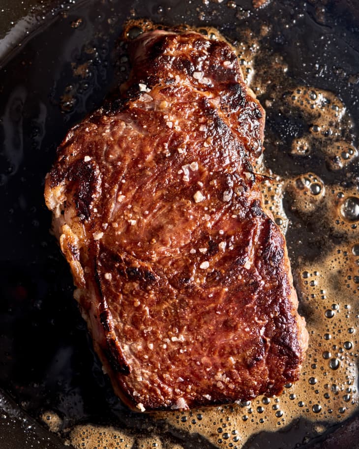strip steak searing in pan