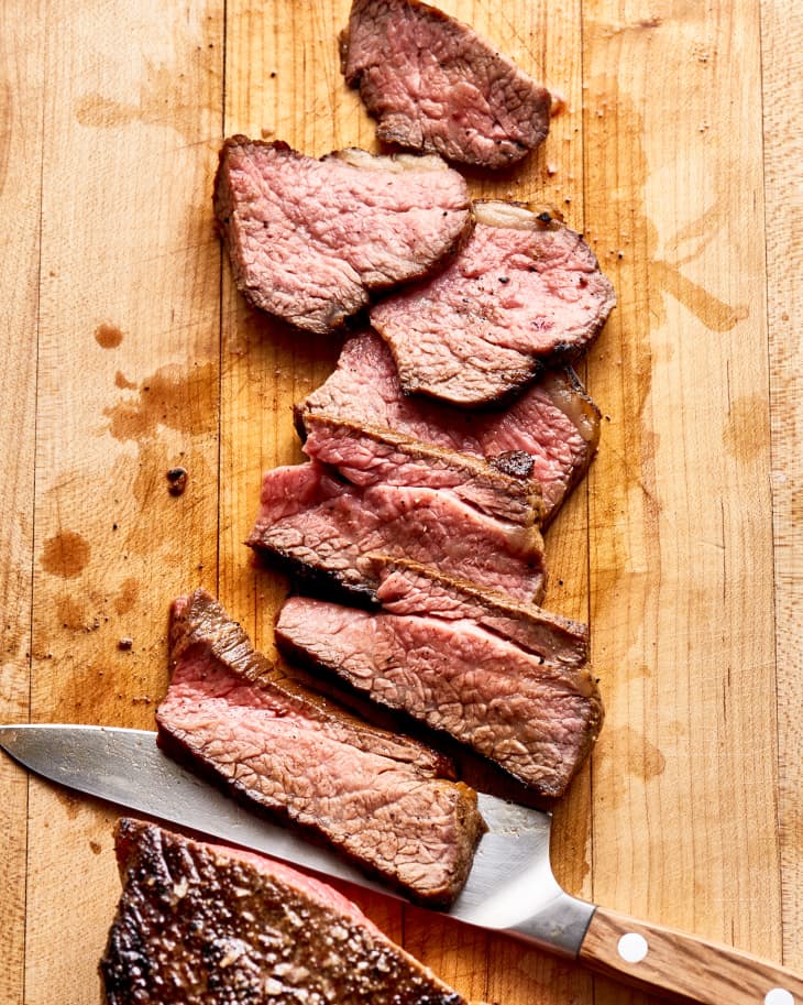 tri tip steak, sliced on a cutting board