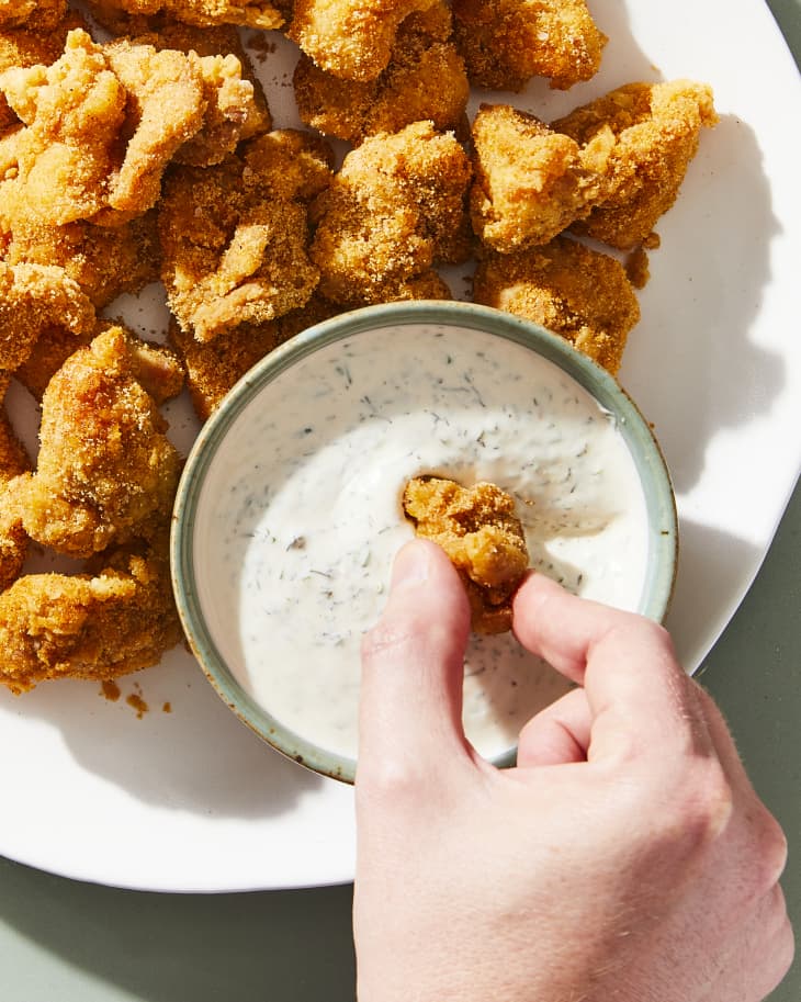 chicken bites with ranch on plate, one being dipped