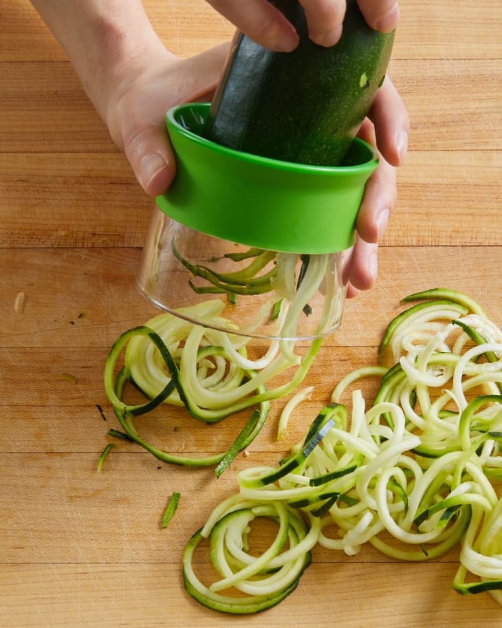 slicing zucchini with a hand spiralizor