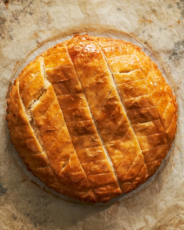 Overhead photo of sliced baked galette de rois on parchment paper