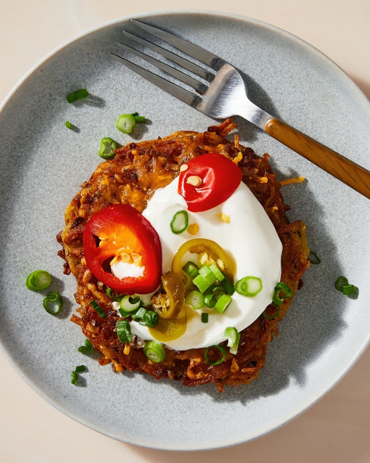 loaded latkes on a plate with tomatoes