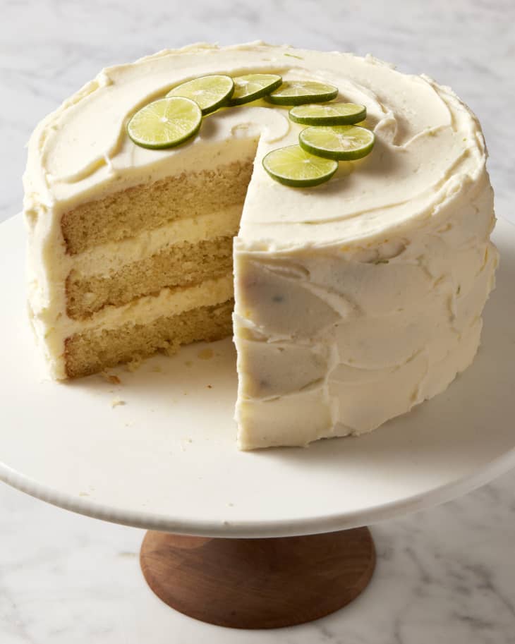 Slice out of key lime cake on cake stand.