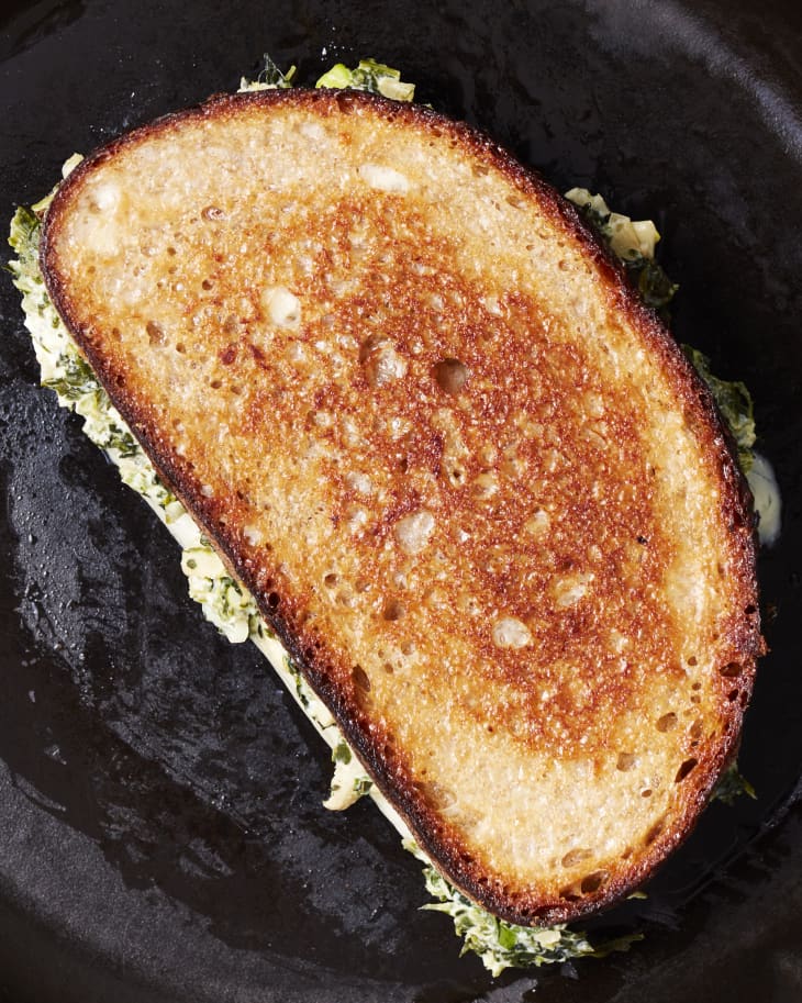 Spinach artichoke grilled cheese in skillet.