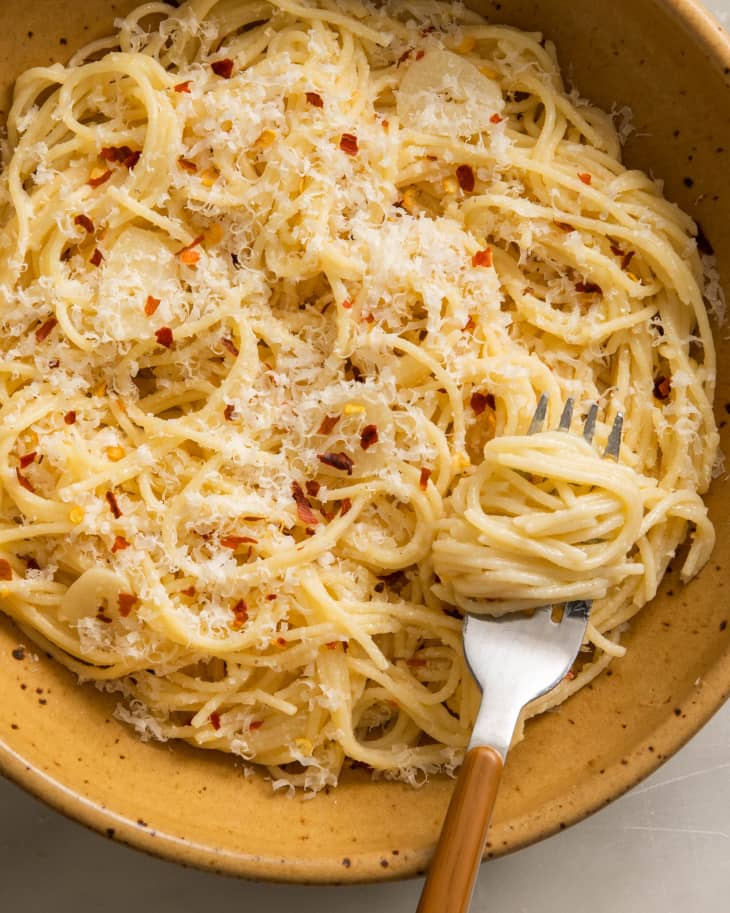 pasta with red pepper and parm on top; fork twirling some