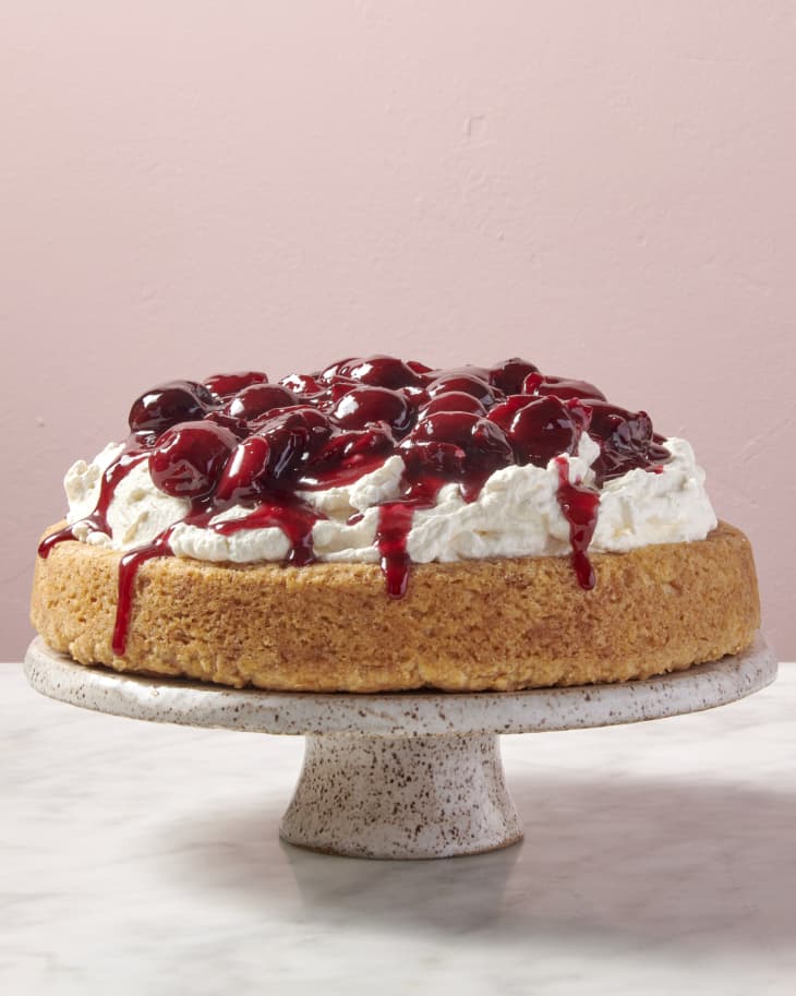 a shortbread cake topped with whipped cream and syrupy cherries