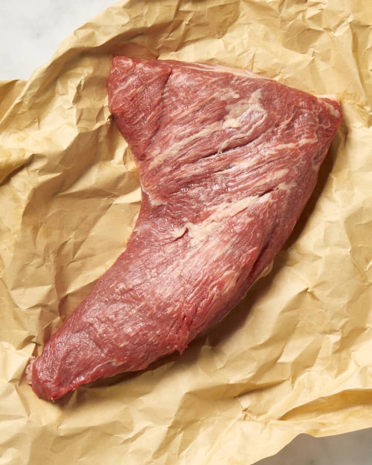 Overhead view of a cut of tri-tip on a piece of brown butcher paper.