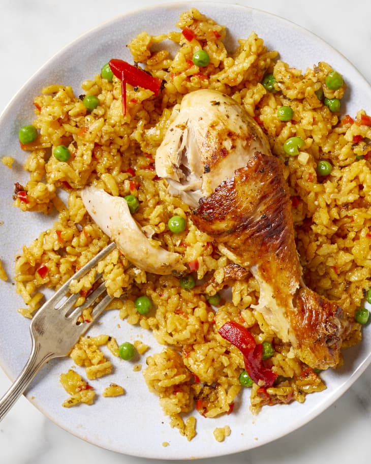 Overhead view of arroz con pollo on a white plate with a fork resting on the plate.