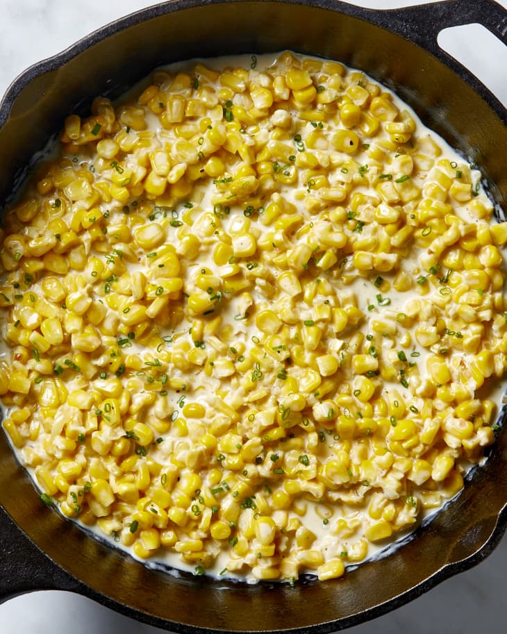 Overhead view of creamed corn in a cast iron pan.