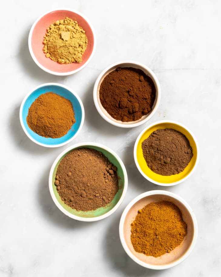Overhead view of assorted spices in mulitcolored bowls.