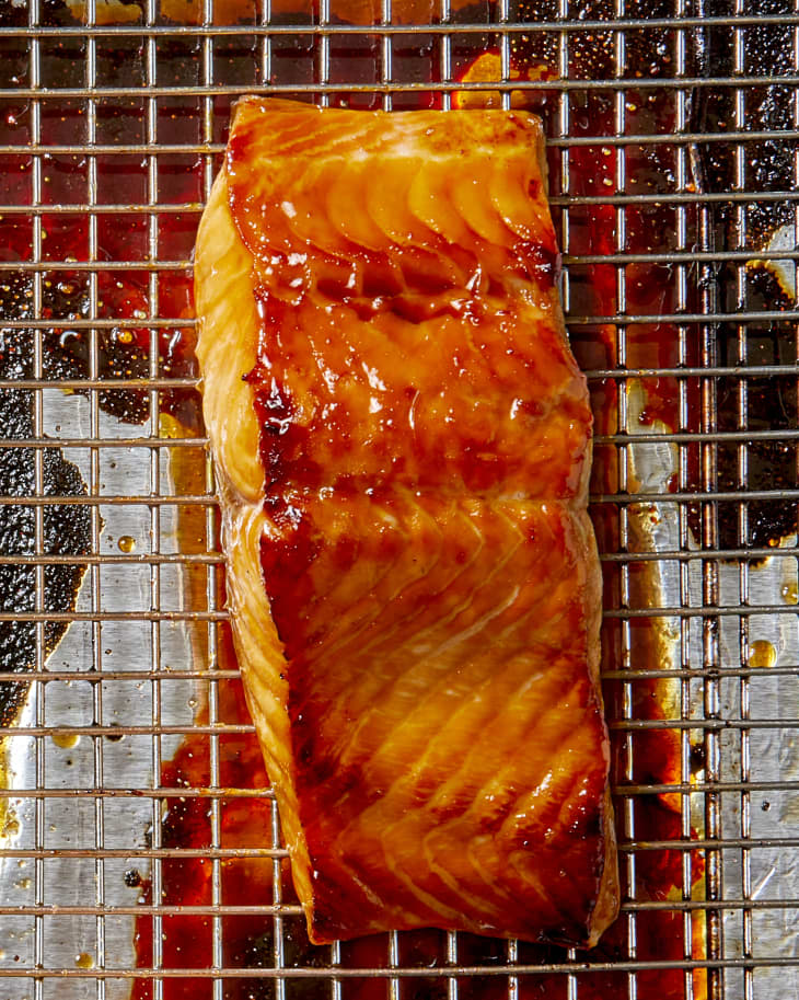 Overhead shot of a piece of baked salmon on a cooking rack, topped with a teriyaki glaze.