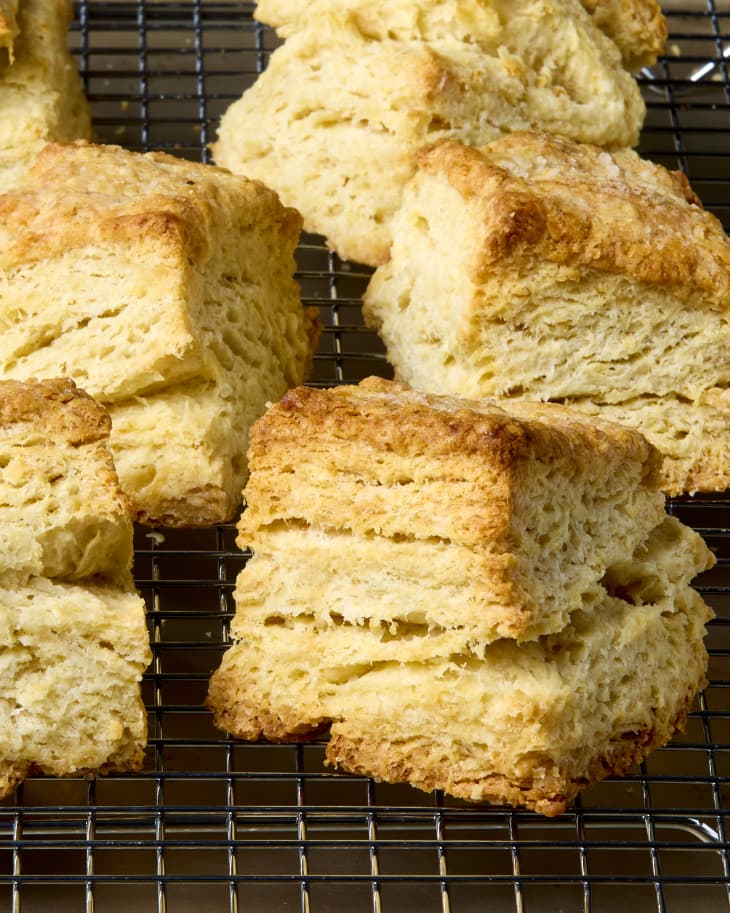 Flaky biscuits on a baking rack showing multiple layers within each biscuit.
