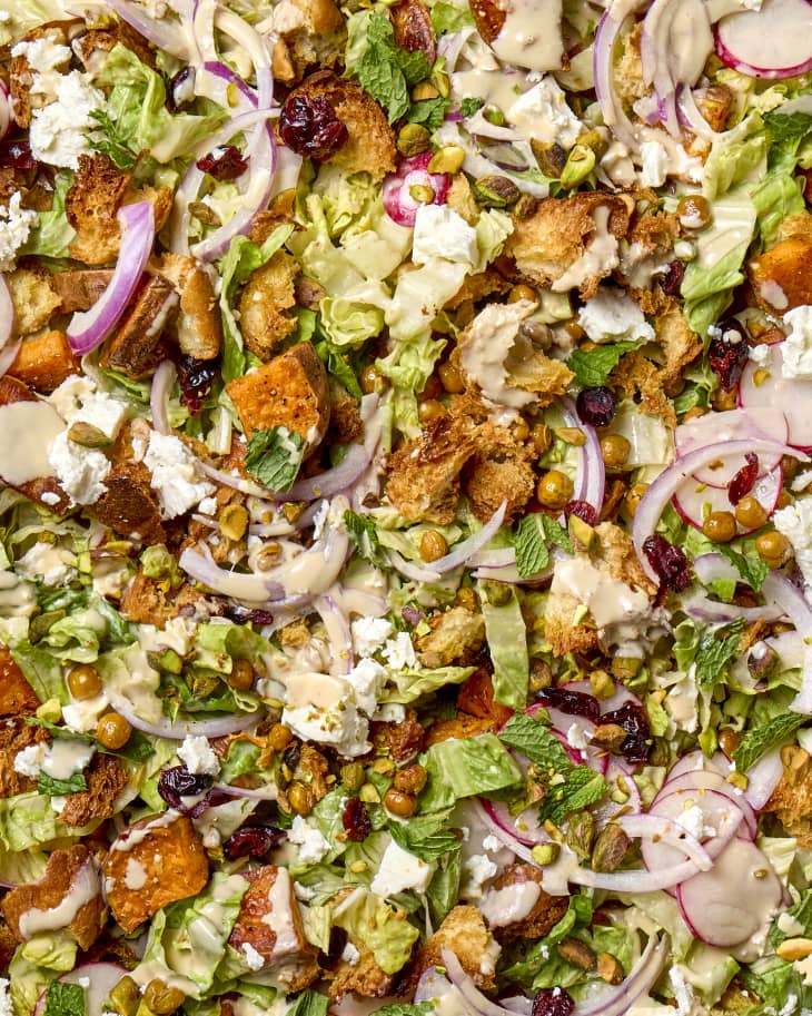 Overhead shot of a sheet pan salad with sweet potatoes, red onion, radishes, chickpeas and feta.