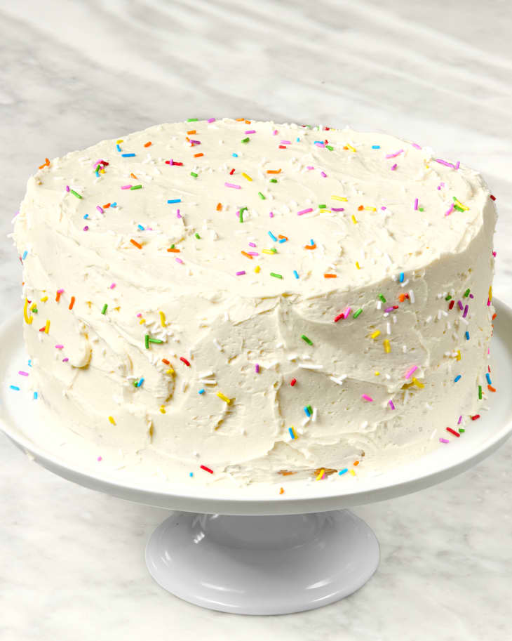 head on shot of a full funfetti cake on a white cake stand.