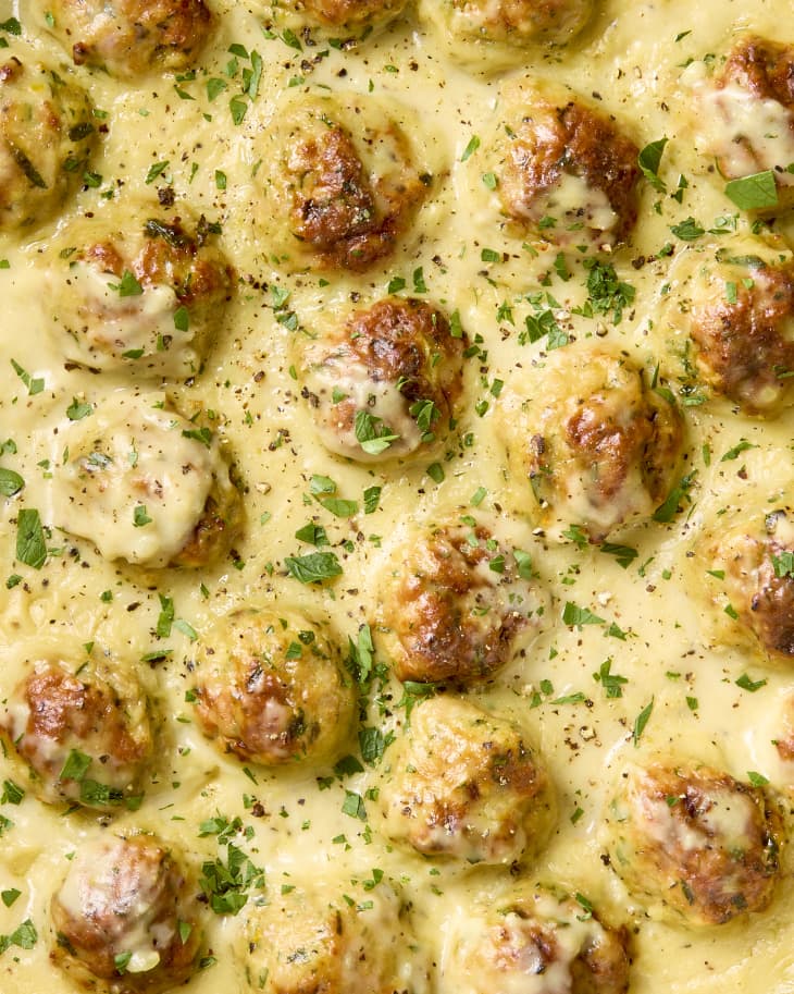 overhead shot of creamy lemon pepper chicken meatballs, topped with herbs.