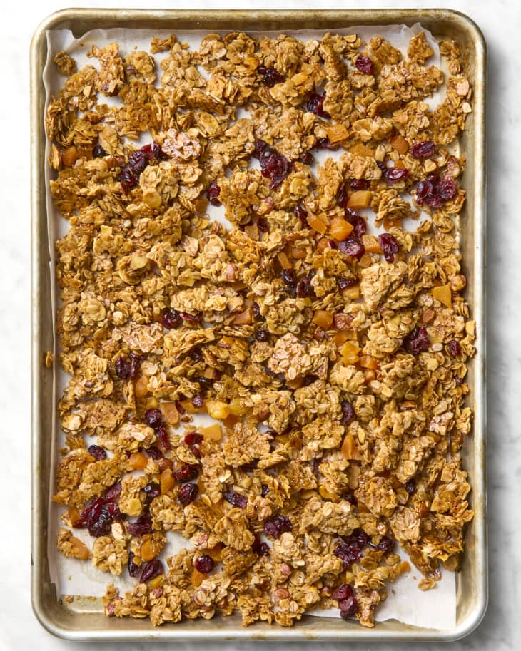 overhead shot of granola spread out on a sheet pan.