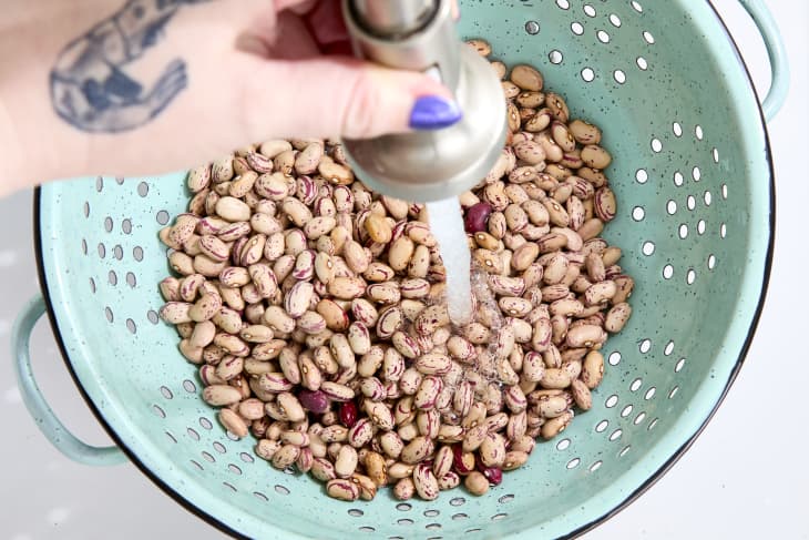 overhead shot of beans being rinsed in a colander