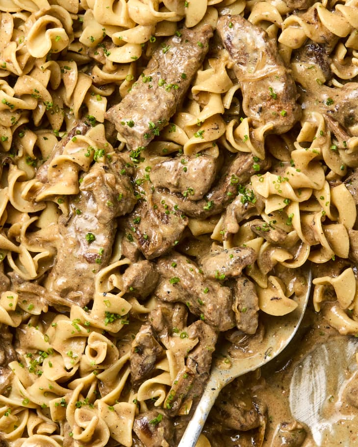 overhead shot of beef stroganoff being scooped up with a spoon.