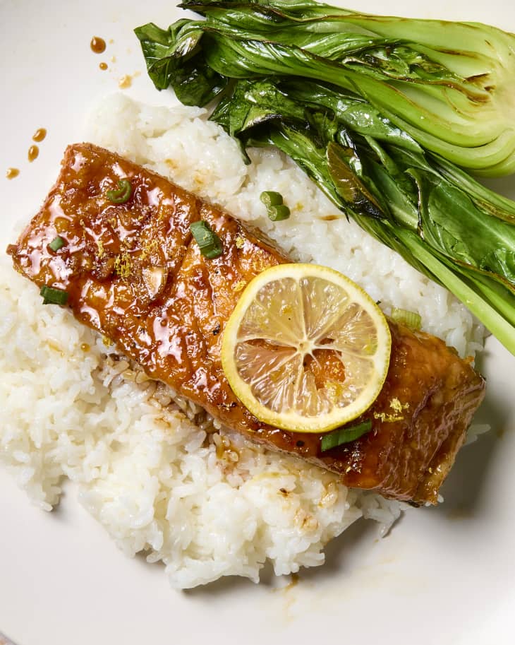 overhead shot of salmon served over white rice and bok choy.