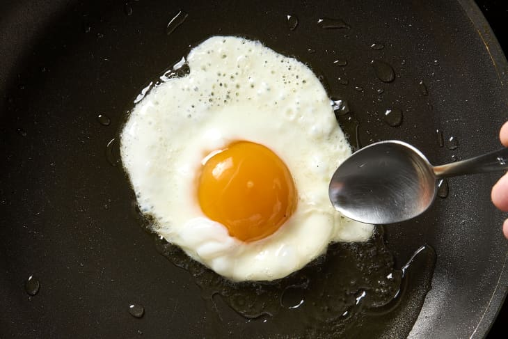overhead shot of a fried egg being made using the basted method.