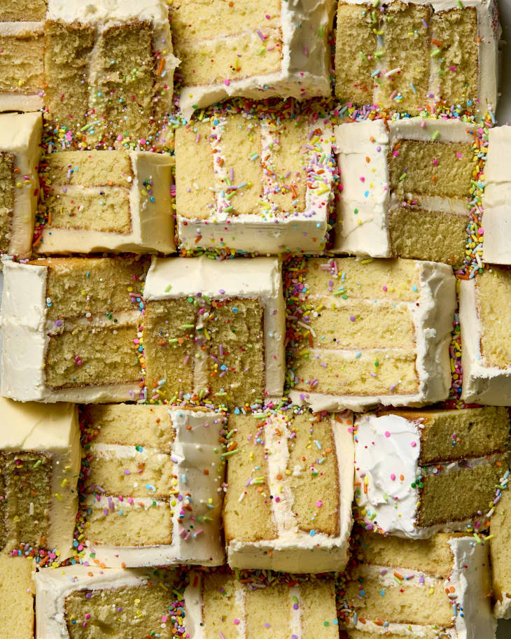 overhead shot of a bunch of vanilla cake slices pushed together, topped with rainbow sprinkles.