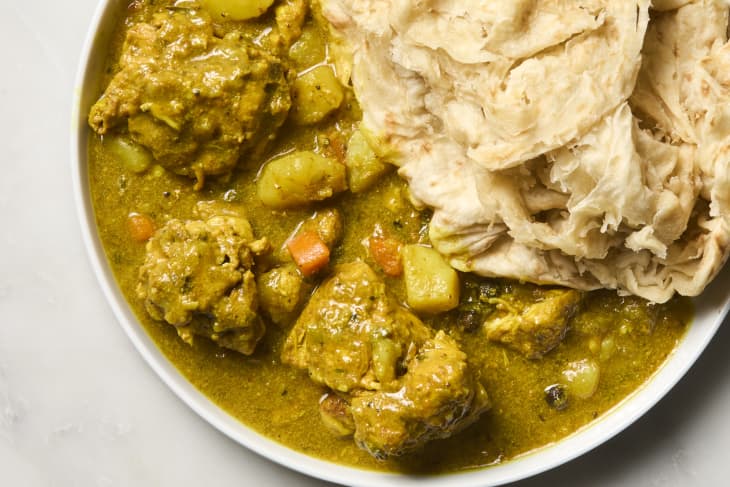 overhead shot of jamaican chicken curry on a plate with roti.
