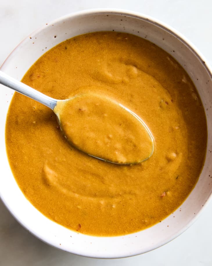 peanut sauce being lifted up by a spoon