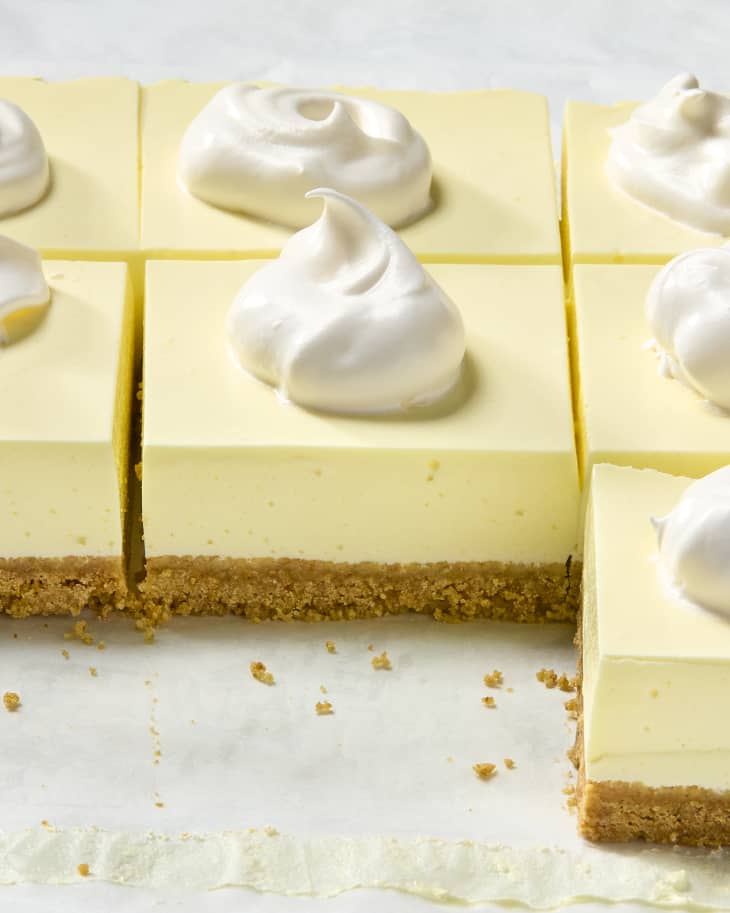 angled shot of a bunch of slices on parchment paper, topped with whipped cream