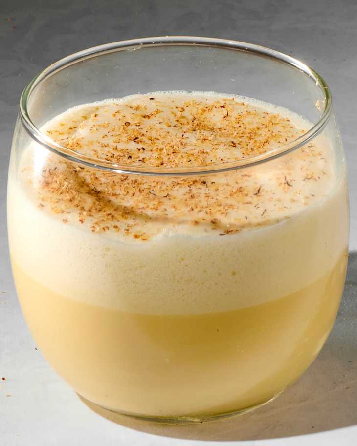 angled shot of a glass of eggnog