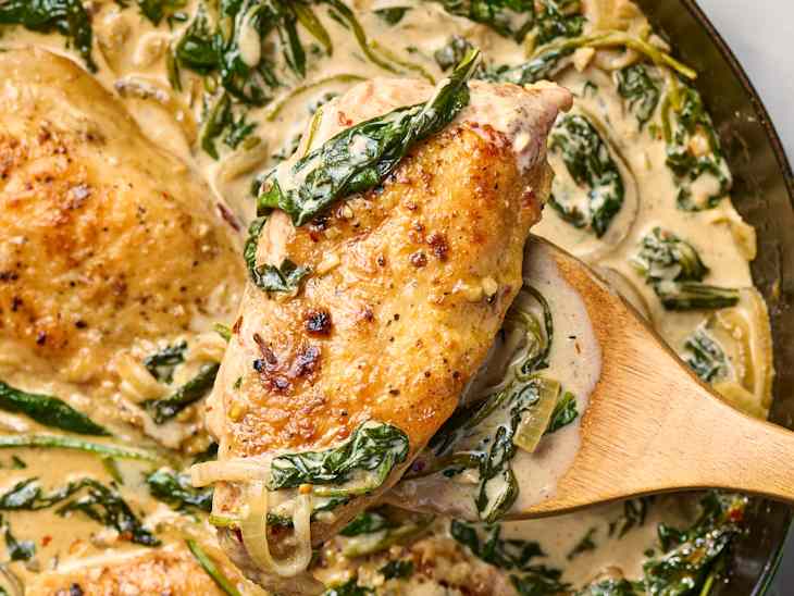 overhead shot of creamy spinach chicken in a green cast iron