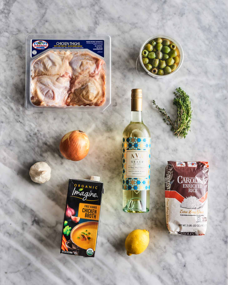 Chicken thighs, white wine, olives and other ingredients on a counter