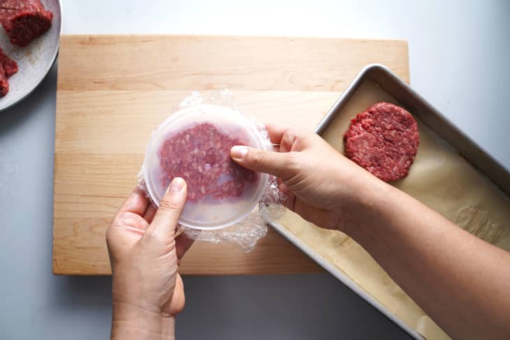Two small plastic lids are used as a press for the burger patties.