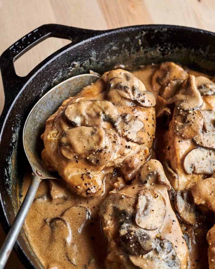Creamy balsamic chicken in skillet with serving spoon.