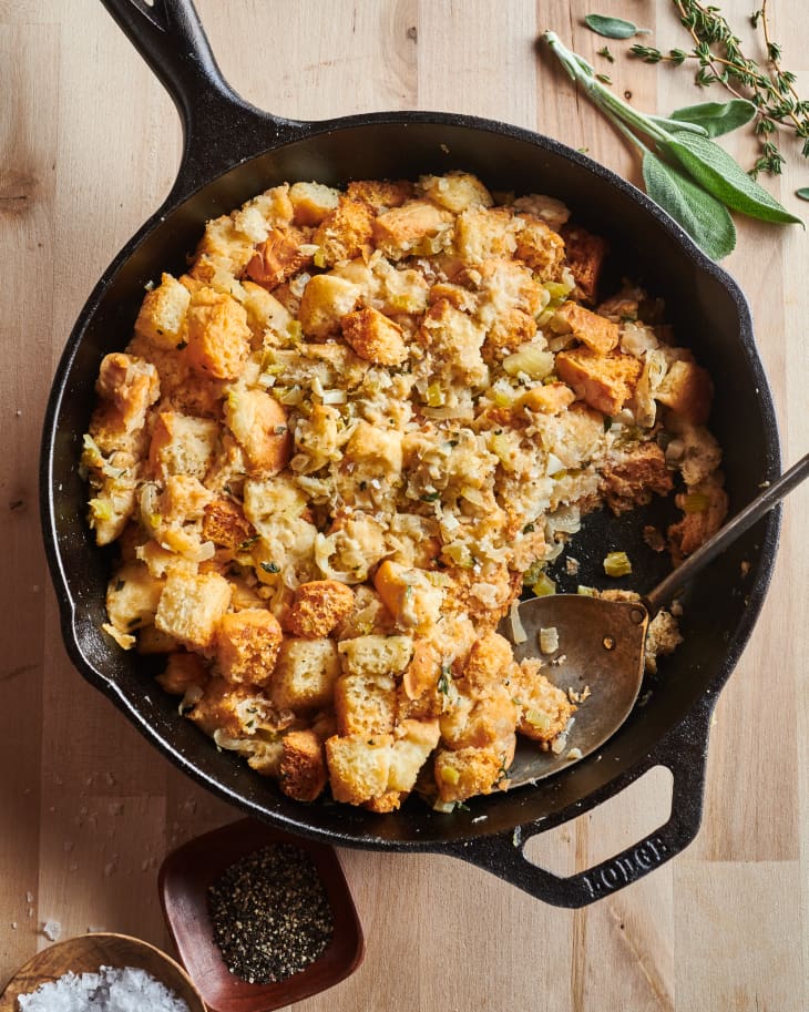 Chrissy Teigen's “Herby King’s Hawaiian Stuffing” in skillet with serving scooped out.