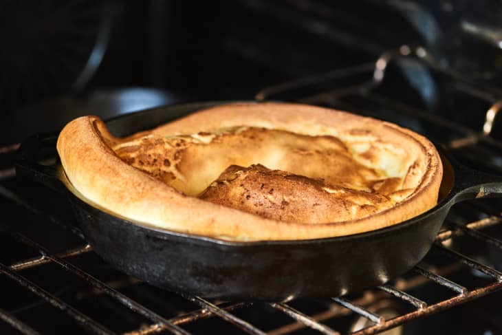 dutch baby rising in the oven in a cast iron pot