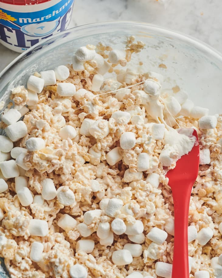 someone is mixing rice krispies and marshmallows in a bowl