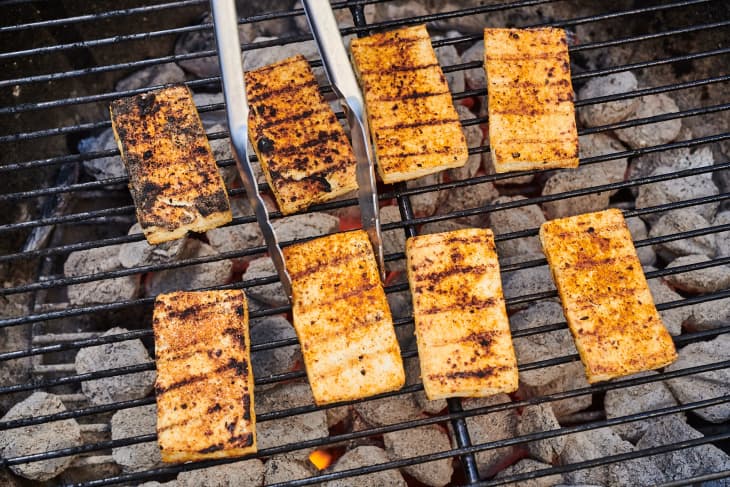 tofu on a grill being flipped