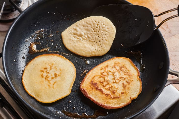 pancakes being flipped on a nonstick pan