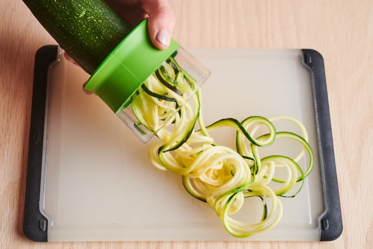 someone is making zoodles with a handheld zoodler