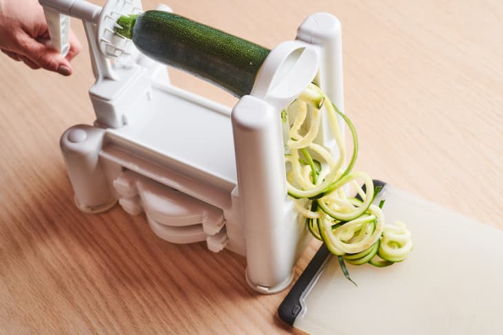 someone is making zoodles with a large zoodle maker