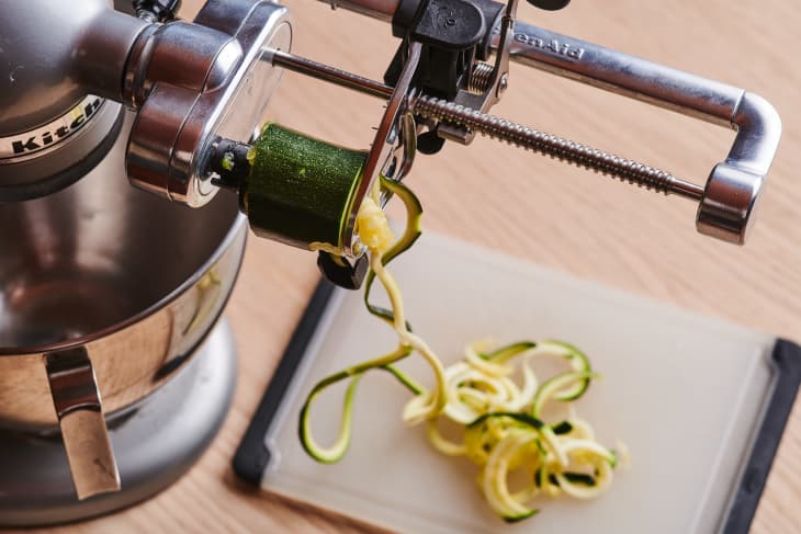 someone is making zoodles with a kitchenaid and attachment