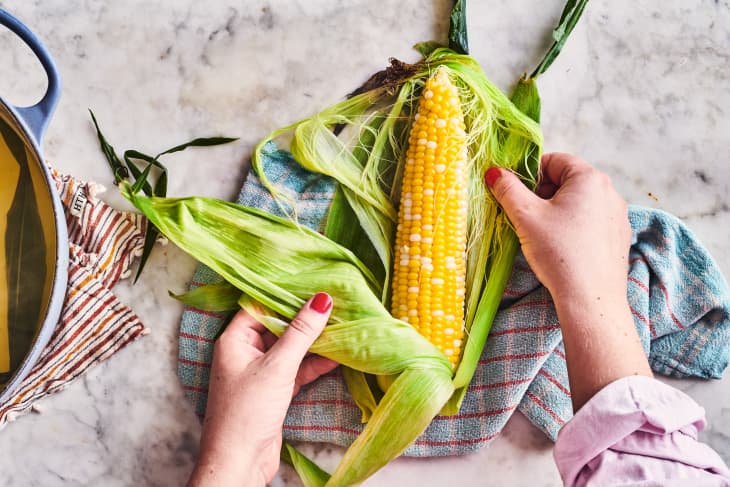 someone pulling corn out of skin