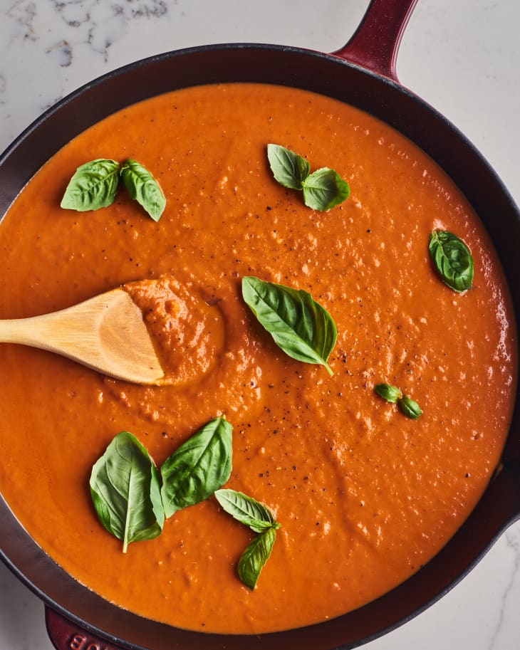 sauce in pan with basil leaves and wooden spoon