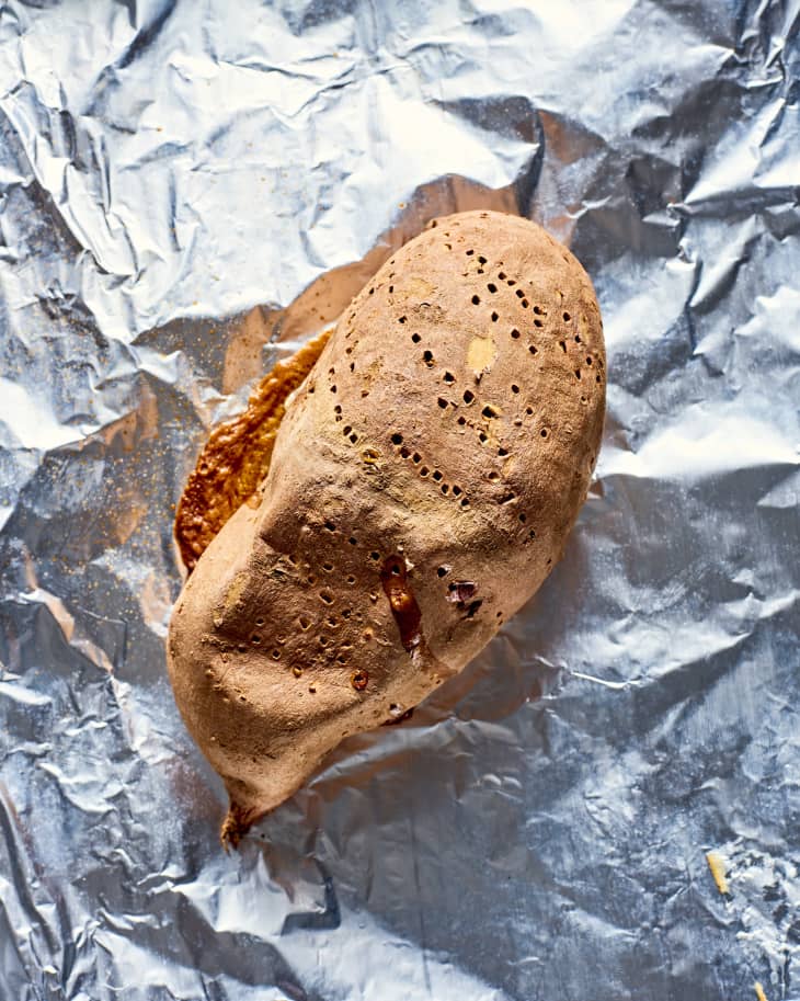 a dry-looking roasted sweet potato on a foil-lined sheet pan