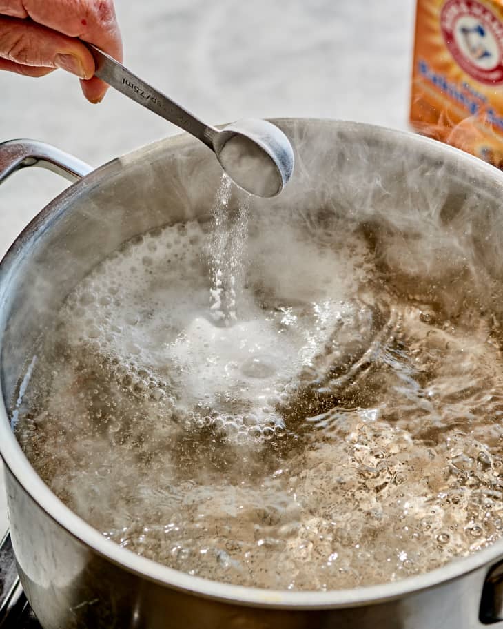 baking soda being dropped into a pot of boiling water