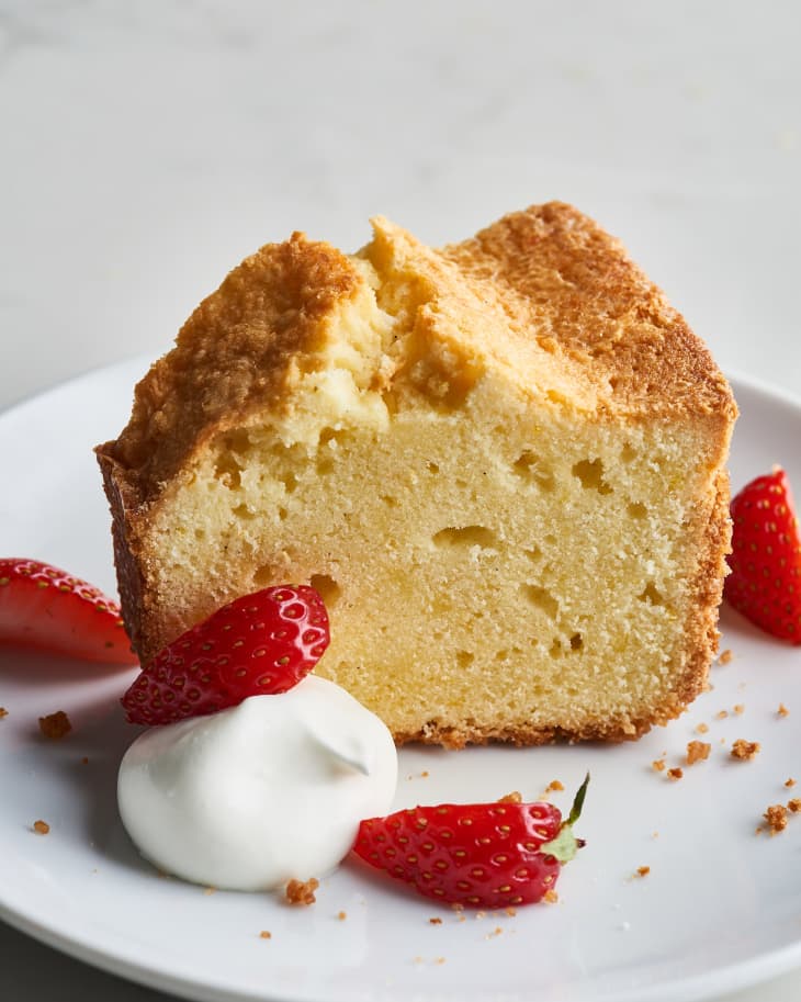 pound cake slice on a plate with cream and strawberries